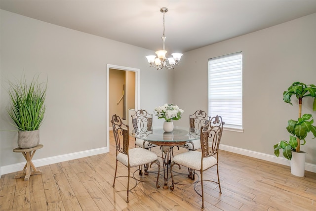 dining space with an inviting chandelier and light hardwood / wood-style flooring