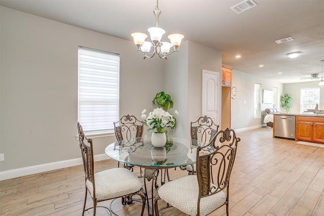 dining room featuring ceiling fan with notable chandelier, plenty of natural light, sink, and light hardwood / wood-style flooring