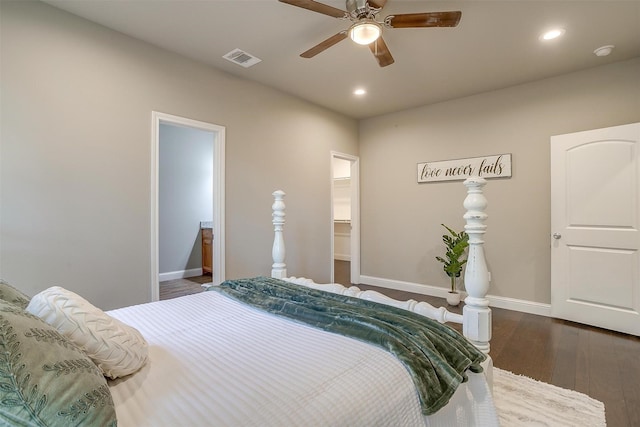 bedroom with a closet, a spacious closet, dark hardwood / wood-style floors, and ceiling fan