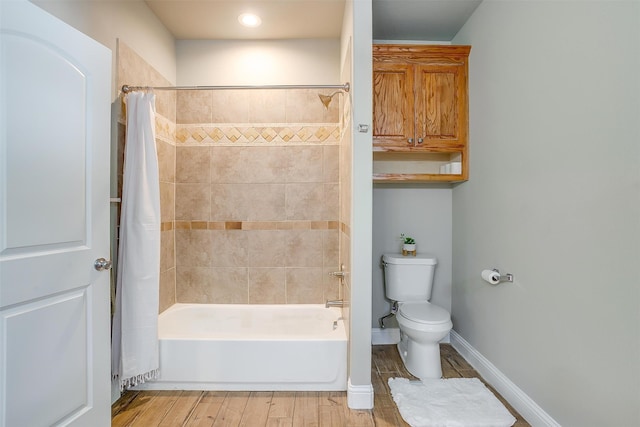 bathroom with shower / bath combo, hardwood / wood-style flooring, and toilet