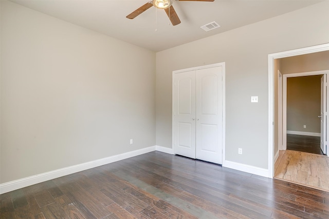 unfurnished bedroom featuring dark hardwood / wood-style flooring, a closet, and ceiling fan