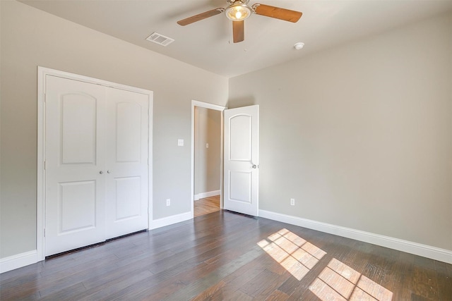 unfurnished bedroom featuring dark hardwood / wood-style floors, ceiling fan, and a closet