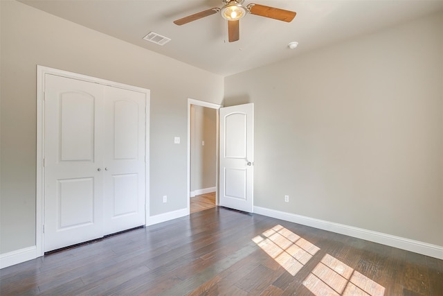 unfurnished bedroom featuring ceiling fan, a closet, and dark hardwood / wood-style floors