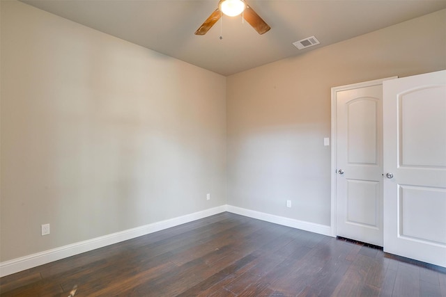 empty room with dark hardwood / wood-style flooring and ceiling fan