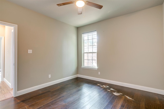 empty room with ceiling fan and dark wood-type flooring