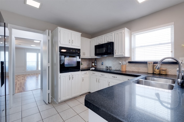 kitchen featuring backsplash, white cabinets, sink, black appliances, and light tile patterned flooring