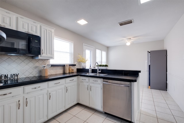 kitchen with white cabinets, light tile patterned floors, sink, kitchen peninsula, and black appliances