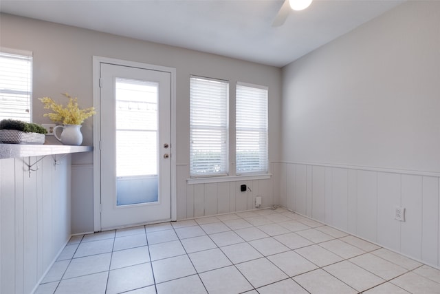 doorway to outside with light tile patterned floors, a wealth of natural light, and ceiling fan