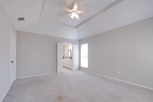 carpeted empty room featuring ceiling fan and a tray ceiling