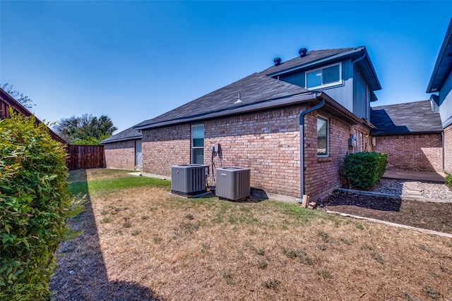 back of house featuring a yard and central AC