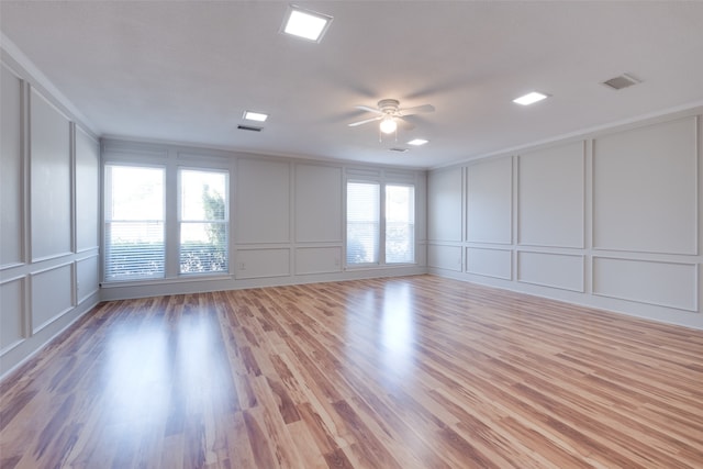 empty room featuring ceiling fan, a wealth of natural light, and hardwood / wood-style flooring