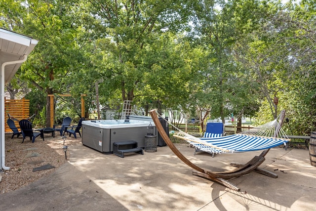 view of patio / terrace with an outdoor fire pit and a hot tub