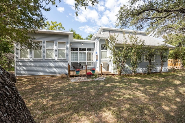 back of property with cooling unit, a sunroom, and a lawn