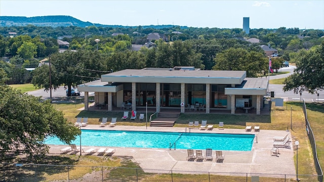 community pool featuring a yard, a patio area, and fence