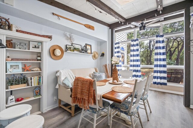 dining space featuring hardwood / wood-style flooring and beamed ceiling