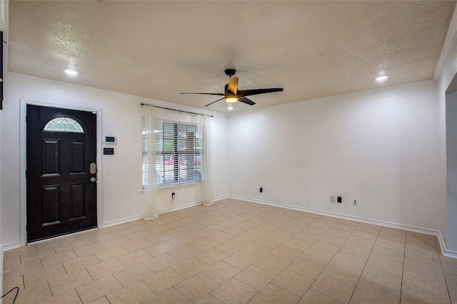 foyer featuring a textured ceiling, ceiling fan, and light tile patterned flooring