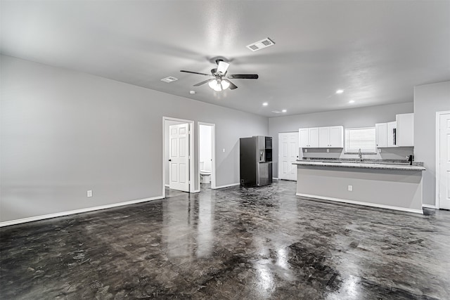 unfurnished living room with ceiling fan and sink