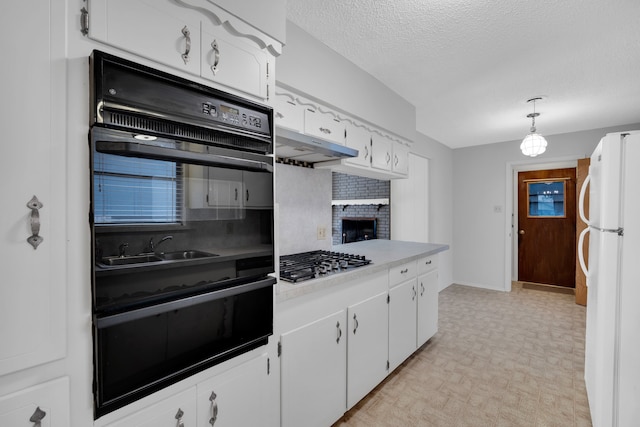 kitchen with stainless steel gas cooktop, white cabinetry, a fireplace, light colored carpet, and white fridge