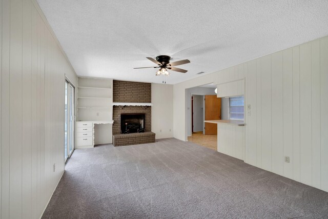 714 Rea Ave, Lancaster, TX 75146 - unfurnished living room featuring wooden walls, a textured ceiling, ceiling fan, and light carpet