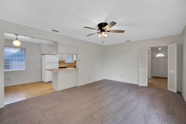 714 Rea Ave, Lancaster, TX 75146 - unfurnished living room featuring light colored carpet, visible vents, ceiling fan, and a textured ceiling