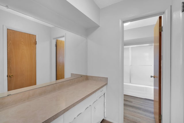 bathroom featuring hardwood / wood-style floors, shower / tub combination, and vanity