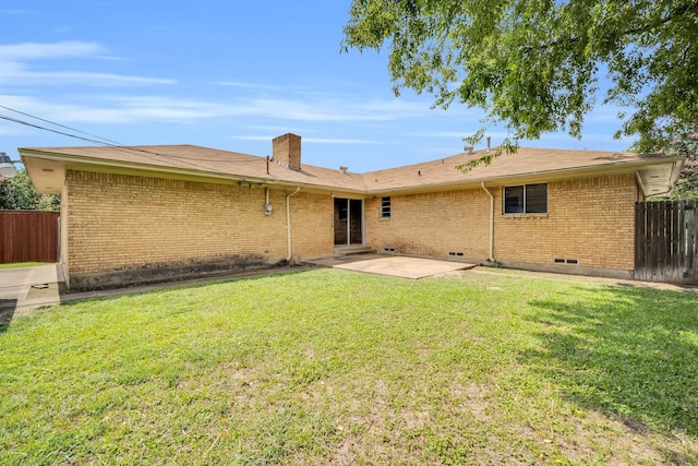 back of property with a patio area and a yard