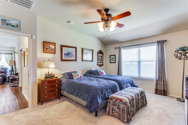 carpeted bedroom with multiple windows and ceiling fan