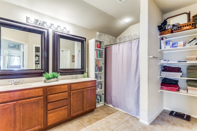 bathroom featuring tile patterned flooring, walk in shower, vanity, and lofted ceiling