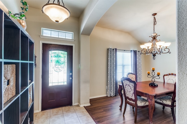 entrance foyer featuring light hardwood / wood-style floors, an inviting chandelier, and lofted ceiling