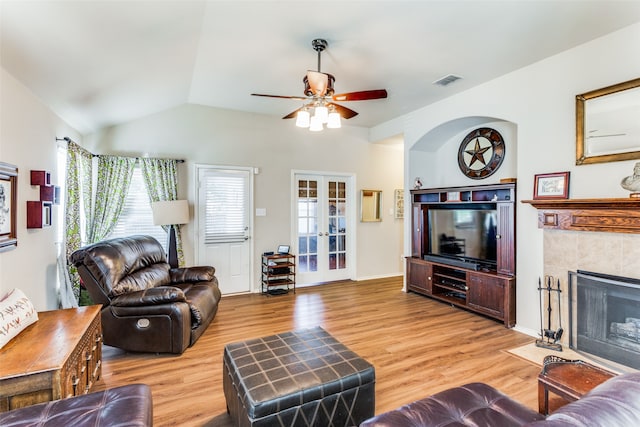 living room featuring ceiling fan, a fireplace, french doors, and hardwood / wood-style floors