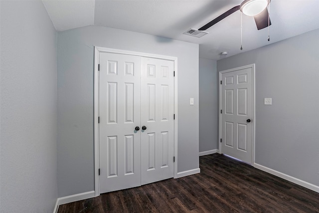 unfurnished bedroom featuring ceiling fan, a closet, vaulted ceiling, and dark wood-type flooring