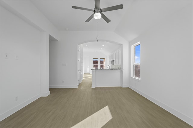 unfurnished living room featuring lofted ceiling, ceiling fan, and light wood-type flooring