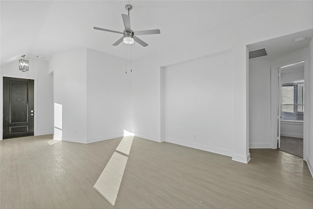 unfurnished living room with ceiling fan with notable chandelier and light hardwood / wood-style floors