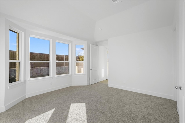 unfurnished room with carpet floors and vaulted ceiling