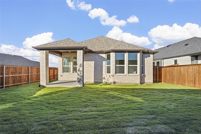 back of house featuring a lawn and a patio area