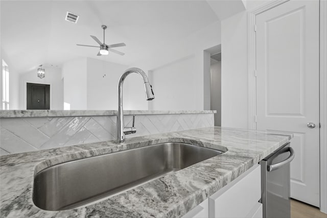 kitchen with light hardwood / wood-style floors, light stone countertops, lofted ceiling, and sink