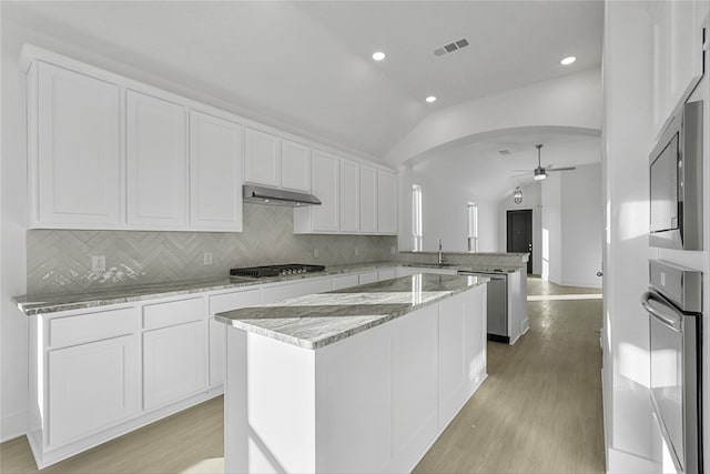 kitchen featuring ceiling fan, white cabinetry, kitchen peninsula, and vaulted ceiling