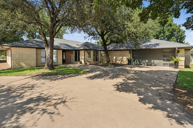 ranch-style home with a garage, concrete driveway, and brick siding