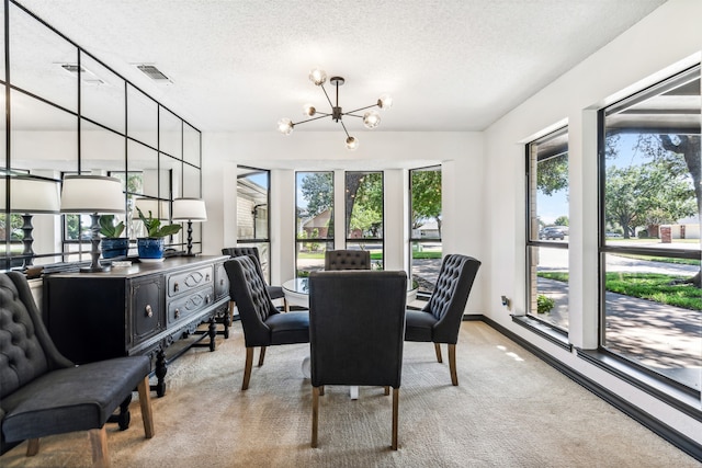 carpeted dining room featuring plenty of natural light, a chandelier, and a textured ceiling