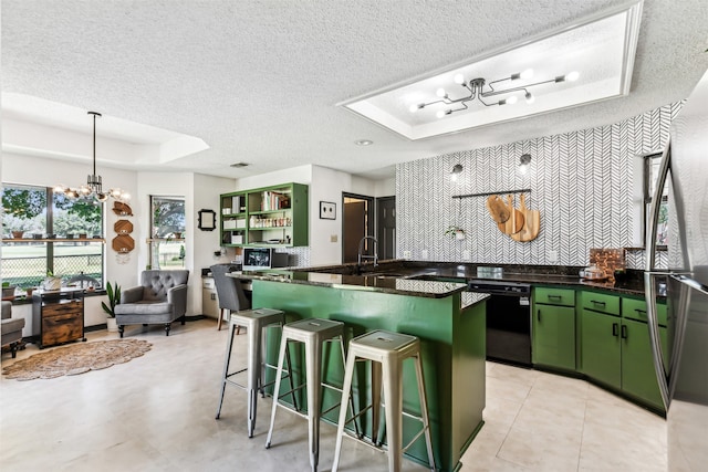 kitchen featuring a textured ceiling, a raised ceiling, dishwasher, green cabinets, and a kitchen bar