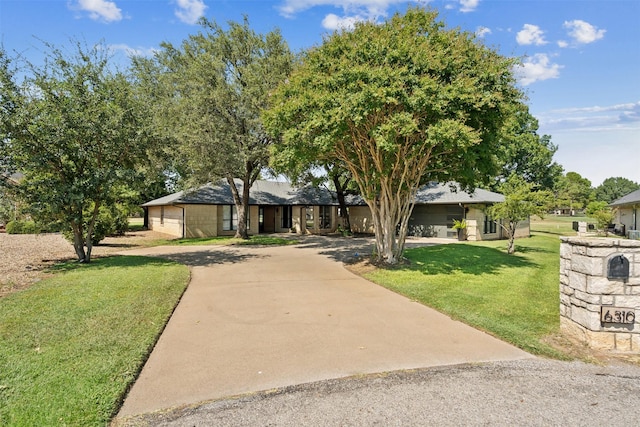 view of front of property with concrete driveway and a front yard