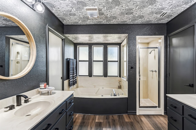 bathroom with vanity, hardwood / wood-style floors, and plus walk in shower