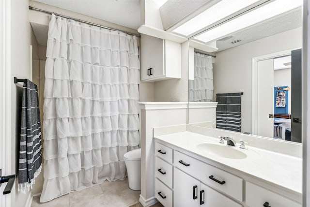 bathroom with vanity, toilet, and tile patterned flooring