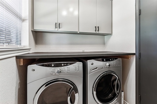 clothes washing area featuring cabinets and independent washer and dryer