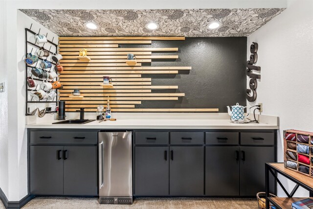 bar featuring stainless steel fridge, sink, and light carpet