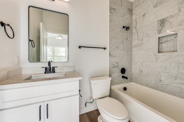 full bathroom with hardwood / wood-style flooring, tiled shower / bath, toilet, and vanity