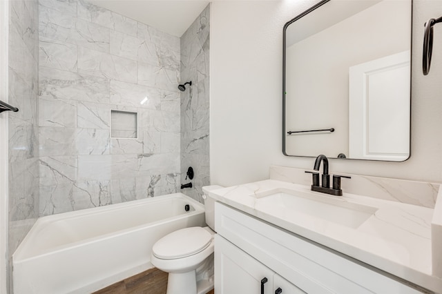 full bathroom with tiled shower / bath, vanity, and toilet