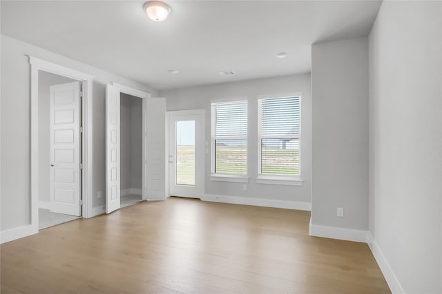 empty room featuring plenty of natural light and light wood-type flooring