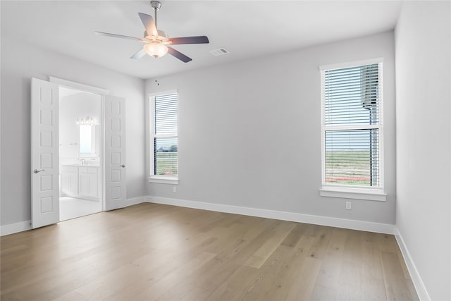 unfurnished room with a healthy amount of sunlight, ceiling fan, and light hardwood / wood-style floors