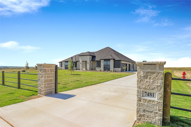 view of front of home with a rural view and a front lawn